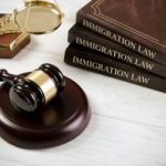 A judge 's gavel and three law books on immigration.