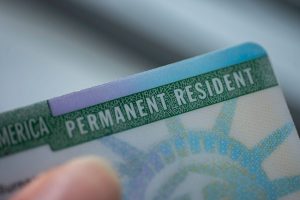 A person holding onto the permanent resident card