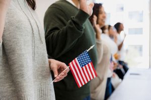 A group of people standing in line holding american flags.